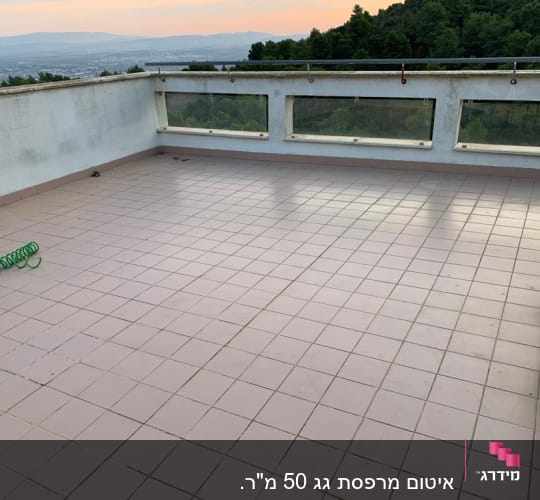 מרפסת מרוצפת עם צינור ירוק ומזגן